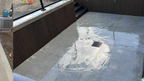 An empty pool outside the house and a pathway on the side